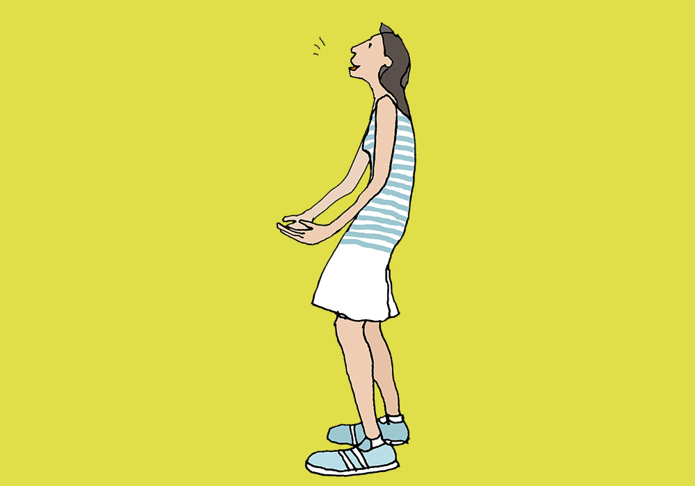 A woman standing, breathing out and swinging her pelvis forward.